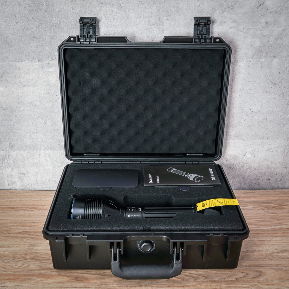 Đèn pin siêu sáng Olight X9R có nguyên một chiếc case nhựa chịu lực để đựng đèn và bộ phụ kiện. phan biet den pin cao cap va den pin kem chat luong